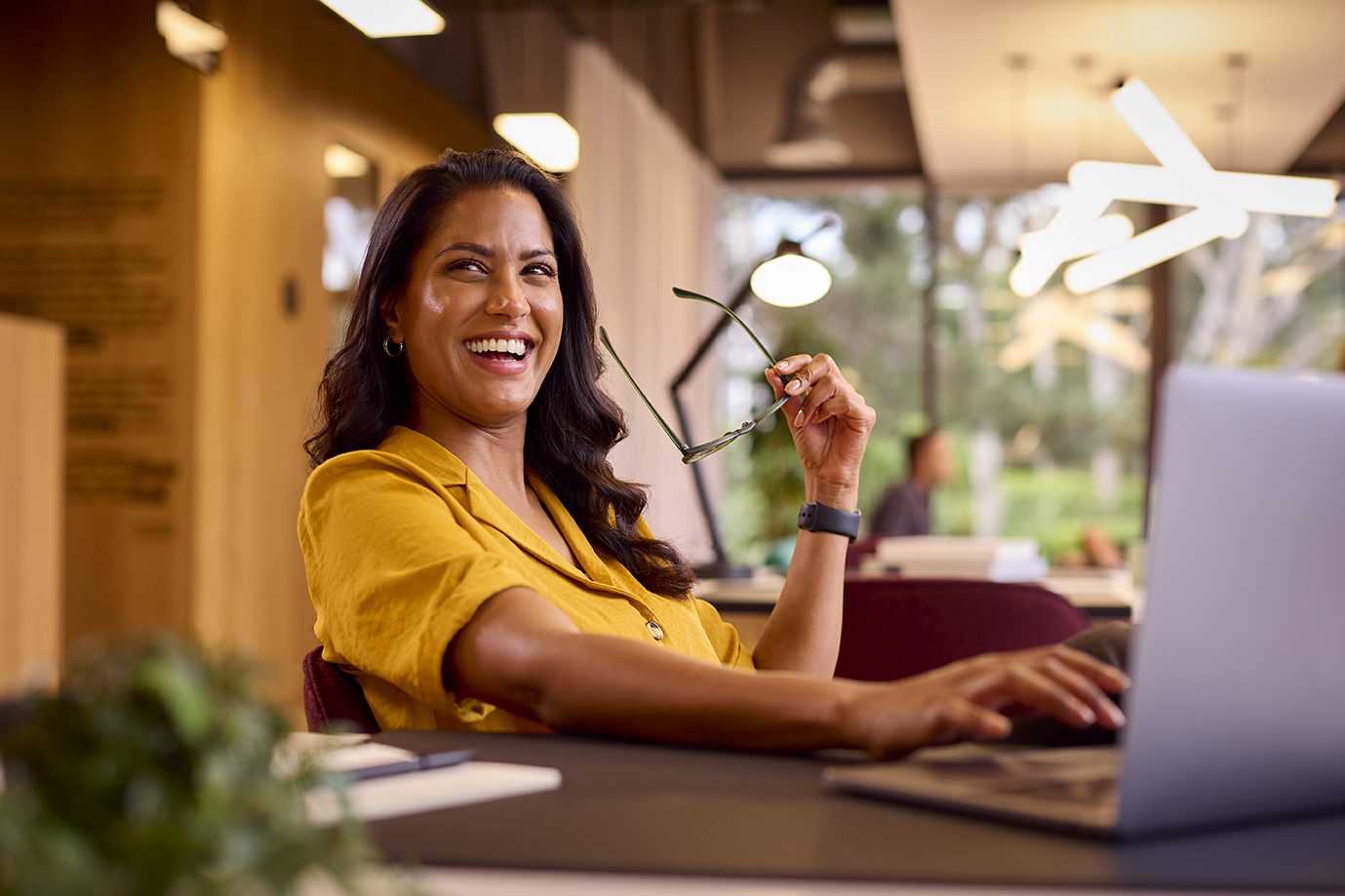 Mature Businesswoman With Glasses Working On Laptop At Desk In Office